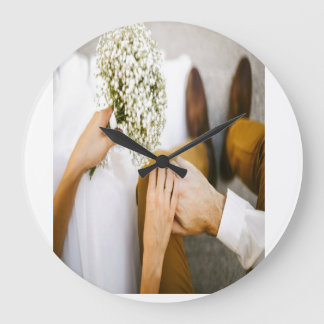 Married couple shak hands  large clock