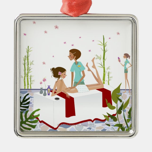 Massage therapist massaging a woman lying on a metal tree decoration (Front)
