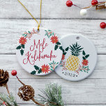 Mele Kalikimaka | Hawaiian Christmas Ceramic Tree Decoration<br><div class="desc">Festive holiday ornament features the Hawaiian Christmas greeting "Mele Kalikimaka" in red hand lettered typography,  surrounded by red poinsettias,  holly leaves and Christmas greenery. Customise the reverse side with the year for a sweet holiday keepsake,  beneath a Christmas pineapple illustration flanked by matching poinsettia flowers and holly.</div>