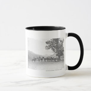 Men with packhorses looking over a hill mug