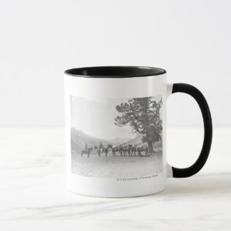 Men with packhorses looking over a hill mug