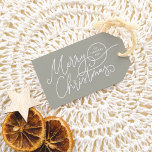 Merry Christmas Calligraphy Elegant Sage Green Gift Tags<br><div class="desc">Add a touch of elegance to your presents with this Christmas gift tag! Featuring “Merry Christmas” in graceful script lettering with delicate flourishes, your family’s name and the year are nestled inside one of the swirling details. The soft sage green background gives a calm, festive feel, and the reverse side...</div>