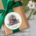 Merry Christmas Family Photo Holly and Pine Classic Round Sticker<br><div class="desc">Merry Christmas stickers with photo and traditional bouquets of holly, pine and pine cone. The colours of the text and background can be changed in the design tool. Your photo is displayed in 16:9 portrait format and the photo template will automatically display them in a pill-shaped, rounded lozenge shape. Please...</div>