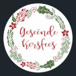 Merry Christmas in Afrikaans Geseënde Kersfees Classic Round Sticker<br><div class="desc">Green and red Christmas holiday wreath design stickers for decorating gifts and envelopes,  with the words Merry Christmas in Afrikaans: Geseënde Kersfees</div>