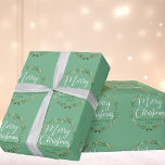 Merry Christmas Pretty Light Green Wreath Custom Wrapping Paper<br><div class="desc">Beautiful white cursive script reading Merry Christmas is scrawled over an elegant holly wreath with pretty green mistletoe. The lovely calligraphy overlaps the holiday vines above your custom text. Perfect personalised holiday gift wrap for a family with their name and year. Lovely light green custom wrapping paper.</div>