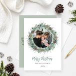Merry Christmas Rustic Greenery Wreath Photo Holiday Card<br><div class="desc">Elegant "Merry Christmas" holiday photo card design features a rustic chic round wreath of winter watercolor greenery framing the family picture and accenting the modern green and charcoal gray wording. Personalize with your last name and the year. Incudes an additional message with family member names and bonus landscape photo on...</div>