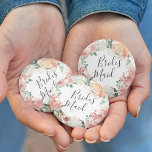 Midsummer Floral Bridesmaid 6 Cm Round Badge<br><div class="desc">Identify the key players at your bridal shower with our elegant,  sweetly chic floral buttons. Button features a watercolor floral wreath of peachy pink peonies,  white hydrangea flowers and botanical greenery with "bridesmaid" inscribed inside in hand lettered script.</div>