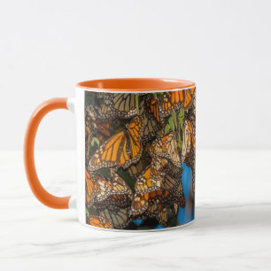 Migrating monarch butterflies cling to leaves mug