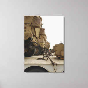 Military vehicles are locked down on semi truck canvas print