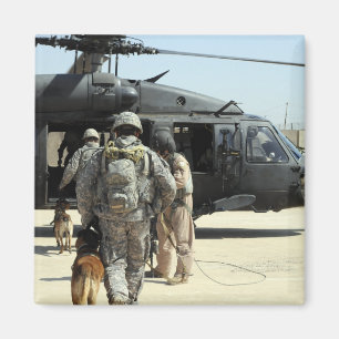 Military working dog handlers board a helicopte magnet