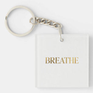 Minimalist typography with gold word breathe key ring