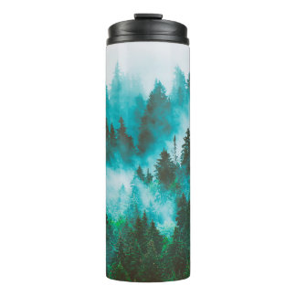Misty foggy mountain landscape with fir forest and thermal tumbler