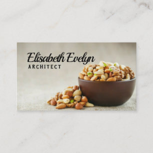 Mix of different nuts in a wooden cup against the business card
