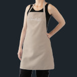 Modern beige tan custom script name solid plain apron<br><div class="desc">Personalised beige tan neutral custom modern script name text monogram solid plain colour girly stylish elegant chic beige tan neutral and white text kitchen Apron. Custom white text on solid plain beige background. Customise, personalise it with name, quote, phrase, or text. Great for cooks, chefs, pottery, ceramics, crafts, work, kitchen,...</div>