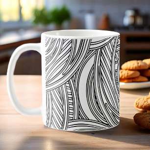 Modern black and white coffee mug with swirls.
