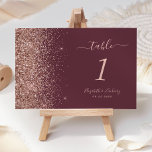 Modern Dark Burgundy Rose Gold Glitter Wedding Table Number<br><div class="desc">The left-hand edge of this elegant modern wedding table number features a rose gold faux glitter design. The customisable text combines pale rose-coloured handwriting,  copperplate and italic fonts on a dark burgundy background.</div>