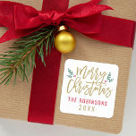 Modern Gold Script Merry Christmas Custom Square Sticker<br><div class="desc">Stylish Merry Christmas holiday favour sticker features antique gold script writing and accents of green branches with holly leaves and red berries. Personalise with custom name / family and year text. The white background colour can be modified.</div>