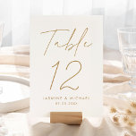 Modern Gold Script Wedding Table Number Card<br><div class="desc">Simple, modern wedding table number cards featuring "Table" displayed in a handwritten gold script with a white background (or a colour of your choosing). To order the gold wedding table cards: add your name, wedding date, and table number. Each number needs to be added to your cart individually. After you...</div>