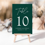 Modern Minimalist Green Wedding Table Number<br><div class="desc">Elegant wedding table number card displaying the word "Table" in a white handwritten script with the table number, your names, and wedding date shown below with a green background. The design repeats on the back. To order the table number cards, simply type each number and add it to your cart....</div>