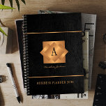 Modern monogram black gold name script elegant planner<br><div class="desc">A classy elegant business or personal 2026 black planner featuring gold copper metallic geometric monogrammed square label on a black leather look background. Perfect for a stylish business image for a business corporate manager, director, fashion stylist, home interior decorator, designer, architect, beauty salon manager, makeup artist, hairstylist. Easy to personalise...</div>