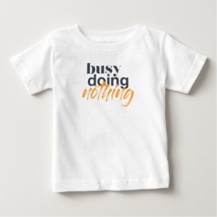 Modern, trendy, urban design of Busy Doing Nothing Baby T-Shirt