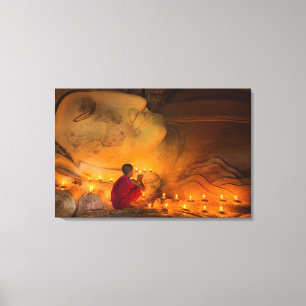Monk Praying By A Buddha Canvas Print