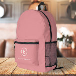 Monogram Rose Pink Feminine Girly Minimal Initial Printed Backpack<br><div class="desc">A simple monogram design with modern typography in white on a blush pink background. The design features a single initial monogram with a minimalist round circle border. The text can easily be customised to suit your needs for the perfectly custom gift or stationery accessory!</div>