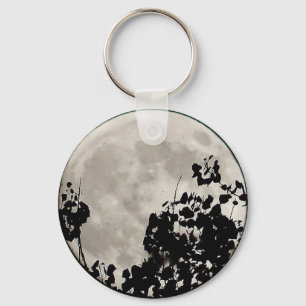 Moon behind dark leaves key ring
