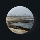 Morro Bay California Coastal Photography 6 Cm Round Badge<br><div class="desc">A foggy overcast day in Morro Bay California with the ocean waves hitting the rocks on the shore in this beach photograph souvenir. This seaside travel photo keepsake button features black cursive script above the beach rocks and grey sky.</div>
