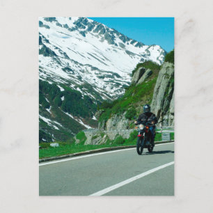 Motorcycle rider in snowy mountains photo postcard