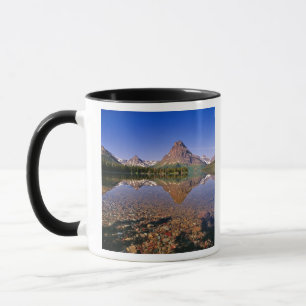 Mountains reflect into calm Two Medicine Lake in Mug