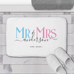 Mr & Mrs Newlywed Couple Wedding Anniversary White Bath Mat<br><div class="desc">Celebrate your holy matrimony with this cute Mr. and Mrs. wedding home bathmat for newlywed couples. Customise it by adding your last name / surname and wedding anniversary year date. Pink, blue and black elegant font on white background. Great for a bridal shower or anniversary / wedding gift for a...</div>