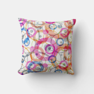 Multi-coloured polka dots, circles on a white cushion