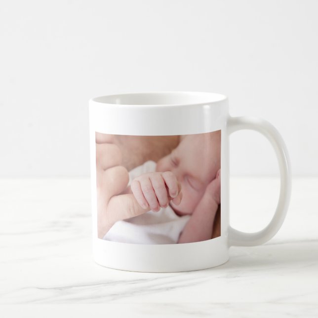 newborn baby holding fathers finger coffee mug (Right)