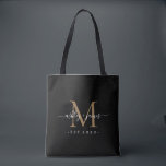 Newlywed Mr Mrs Monogram Names Year Gold Black Tote Bag<br><div class="desc">Chic, modern and simple monogrammed tote bag with your names in white elegant handwritten script calligraphy on a black background with your monogram in gold. Simply add your names, year established and monogram in stylish typography. Perfect luxury gift for the newlywed couple's wedding guests. Exclusively designed for you by Happy...</div>