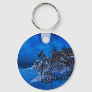 Nighttime winter scene with snow covered pines key ring