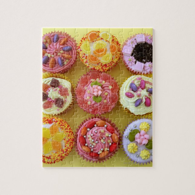 Nine cupcakes each decorated with candy in a jigsaw puzzle (Vertical)