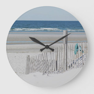 Ocean beach with beach fence large clock