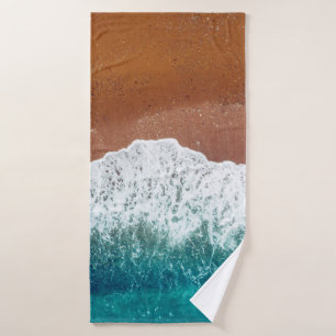 Ocean wave on a sandy beach, background top view bath towel