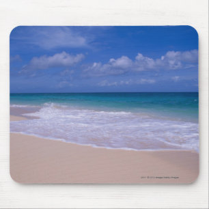 Ocean waves foaming onto sandy beach mouse mat