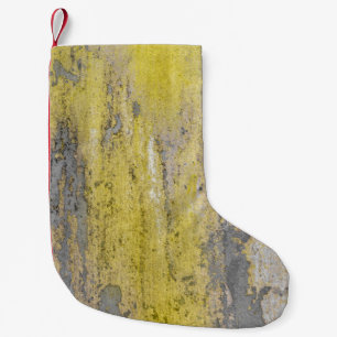 Old gray concrete wall with peeling yellow paint.  small christmas stocking