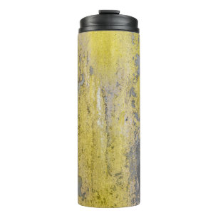 Old gray concrete wall with peeling yellow paint.  thermal tumbler