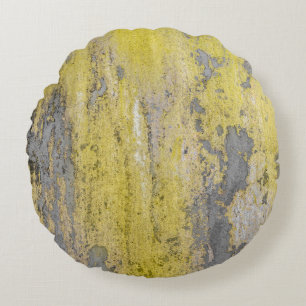 Old grey concrete wall with peeling yellow paint.  round cushion