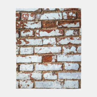 Old vintage brick wall with sprinkled white plaste fleece blanket