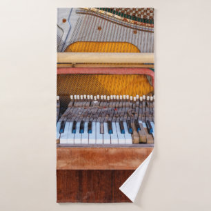 Old vintage piano with the lid off. A dilapidated  Bath Towel