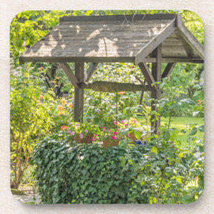 Old well in a garden hard plastic coasters
