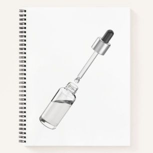 Opened glass dropper bottle with pipette notebook