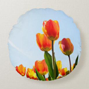 Orange and red tulips from below round cushion
