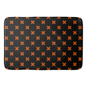 Orange cross stitches on black bath mat