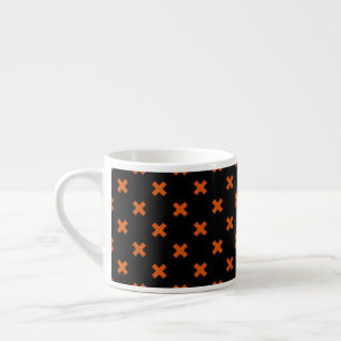 Orange cross stitches on black espresso cup